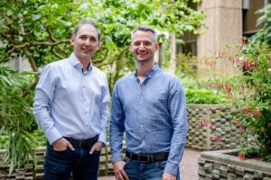 Ilya Ayzenberg (links) und Thomas Grüter wollen das Augenmerk von Medizinerinnen und Medizinern auf die Möglichkeit einer anti-IgLON-Krankheit lenken. (c) RUB/Marquard Two men standing in a garden surrounded by various plants. © RUB/Marquard